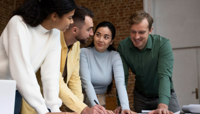 Diverse Group of Adults work together in a meeting room in an office