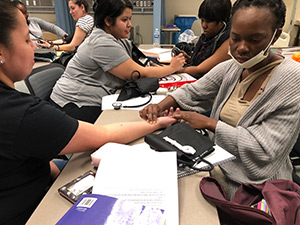 Students practice taking a patients pulse